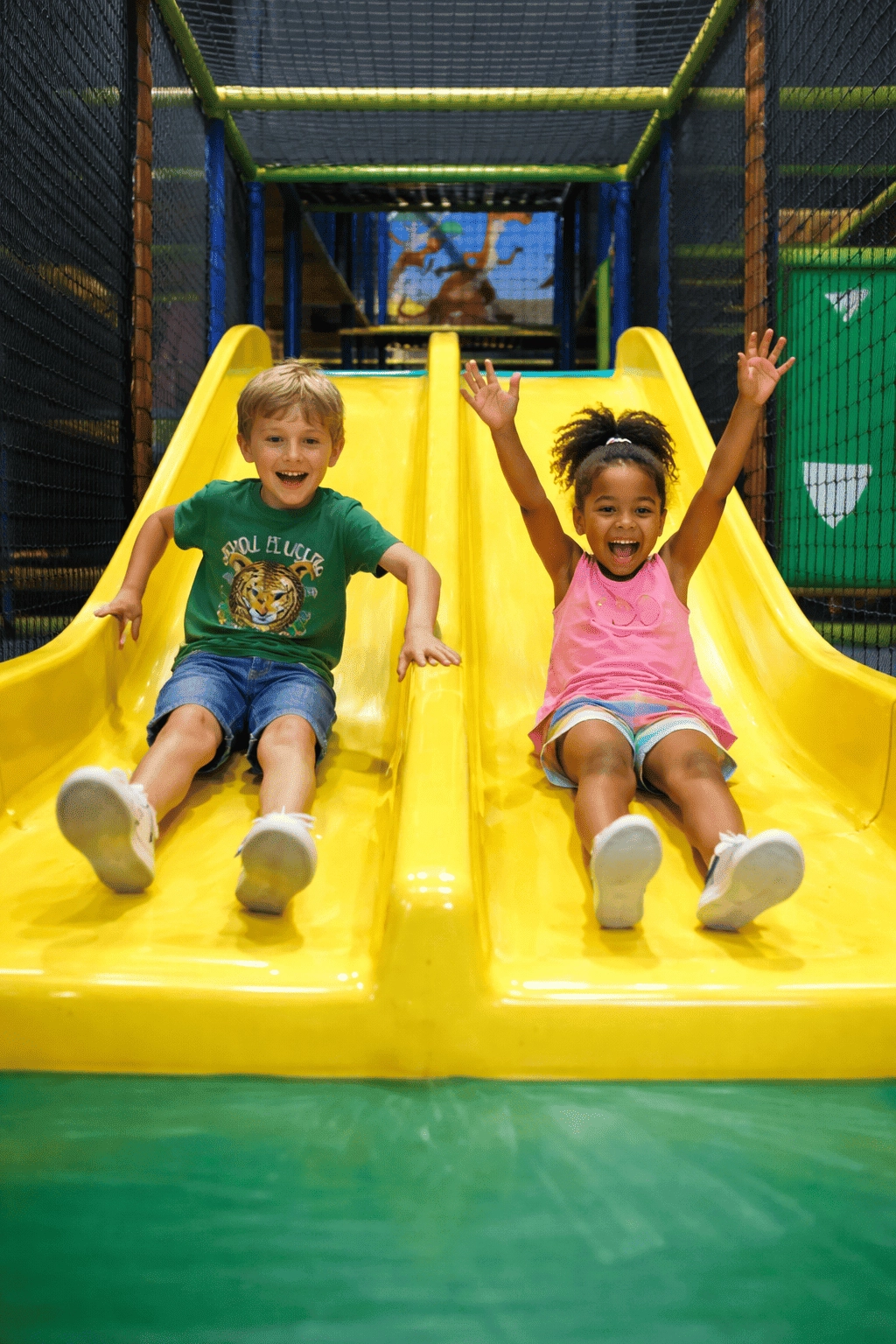 deux enfants glissent toboggan heureux