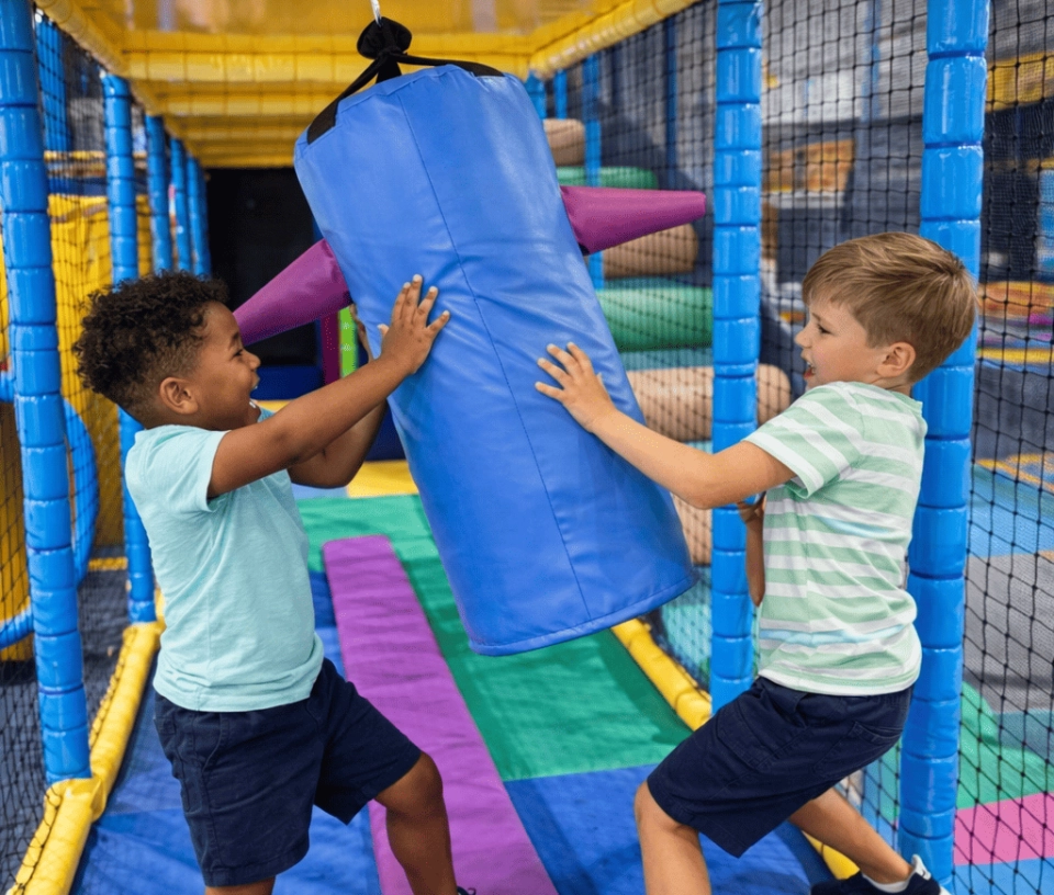 Deux enfants jouant à la pinata dans une aire de jeux pour enfants