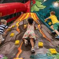 Trois enfants escaladant un Volcan géant
