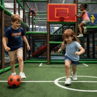 Deux enfants en train de jouer au football dans un Terrain de foot et basket