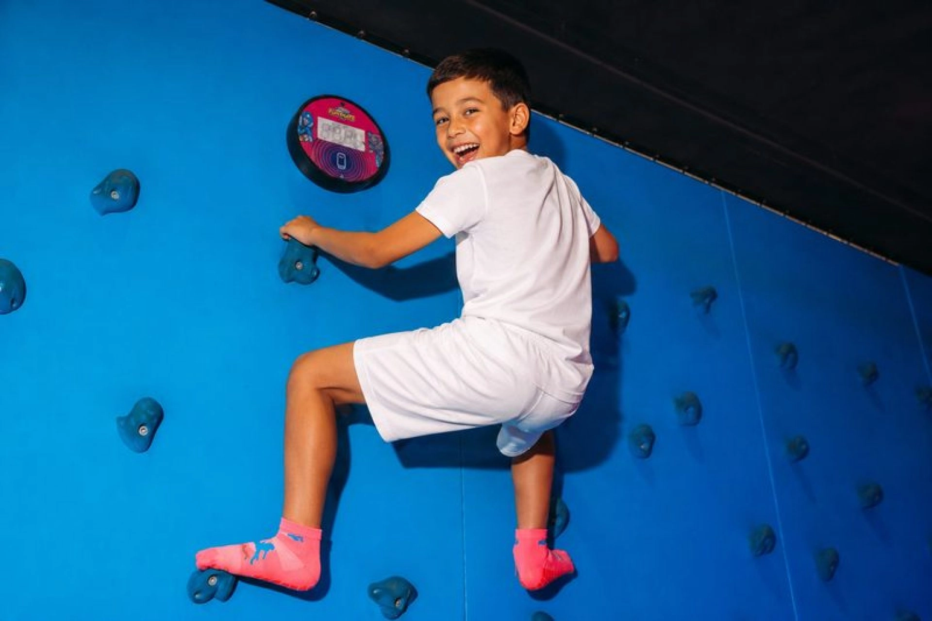 Jeune Garçon escaladant un mur d'escalade garçon