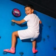 Jeune Garçon escaladant un mur d'escalade garçon