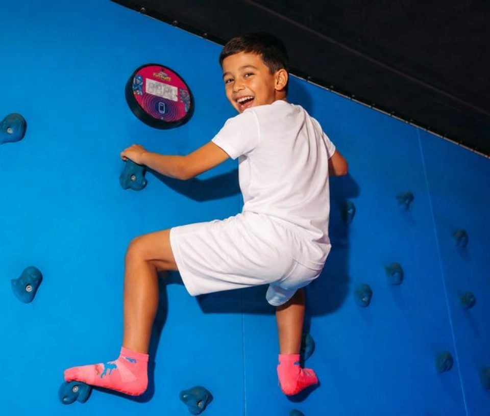 Jeune Garçon escaladant un mur d'escalade garçon