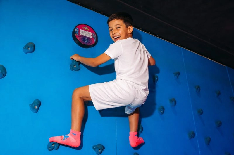 Jeune Garçon escaladant un mur d'escalade garçon
