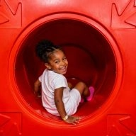 Jeune fille souriante dans un toboggan pour enfants