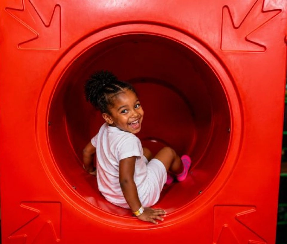 Jeune fille souriante dans un toboggan pour enfants