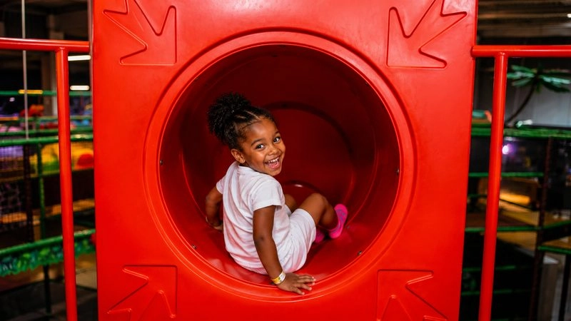 Jeune fille souriante dans un toboggan pour enfants
