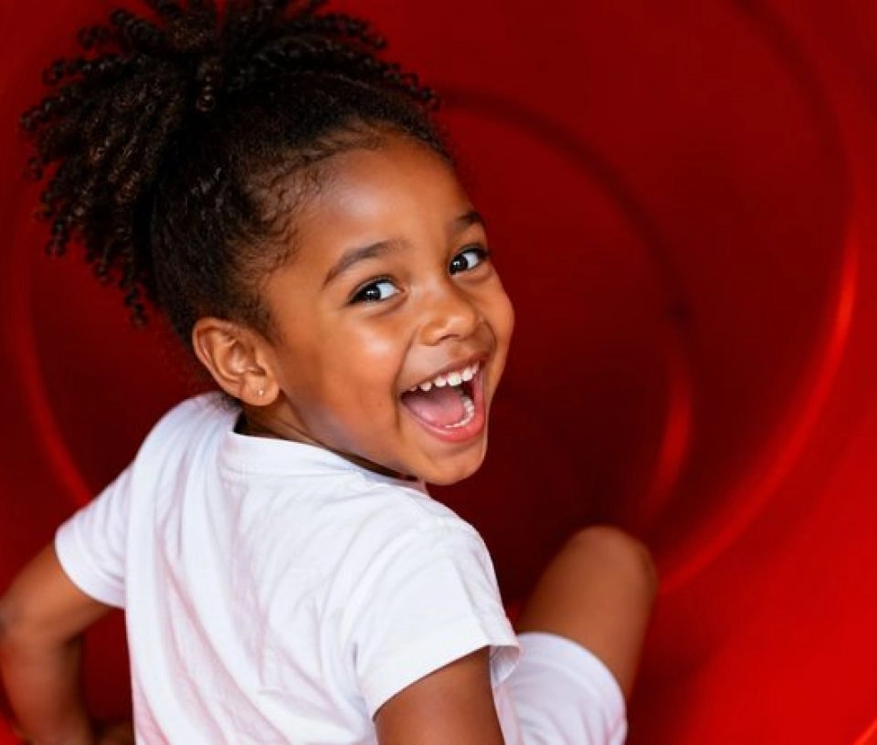 petite fille souriante toboggan parc enfant