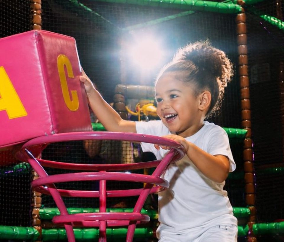 Enfant jouant avec des cubes dans un parc de jeux intérieur