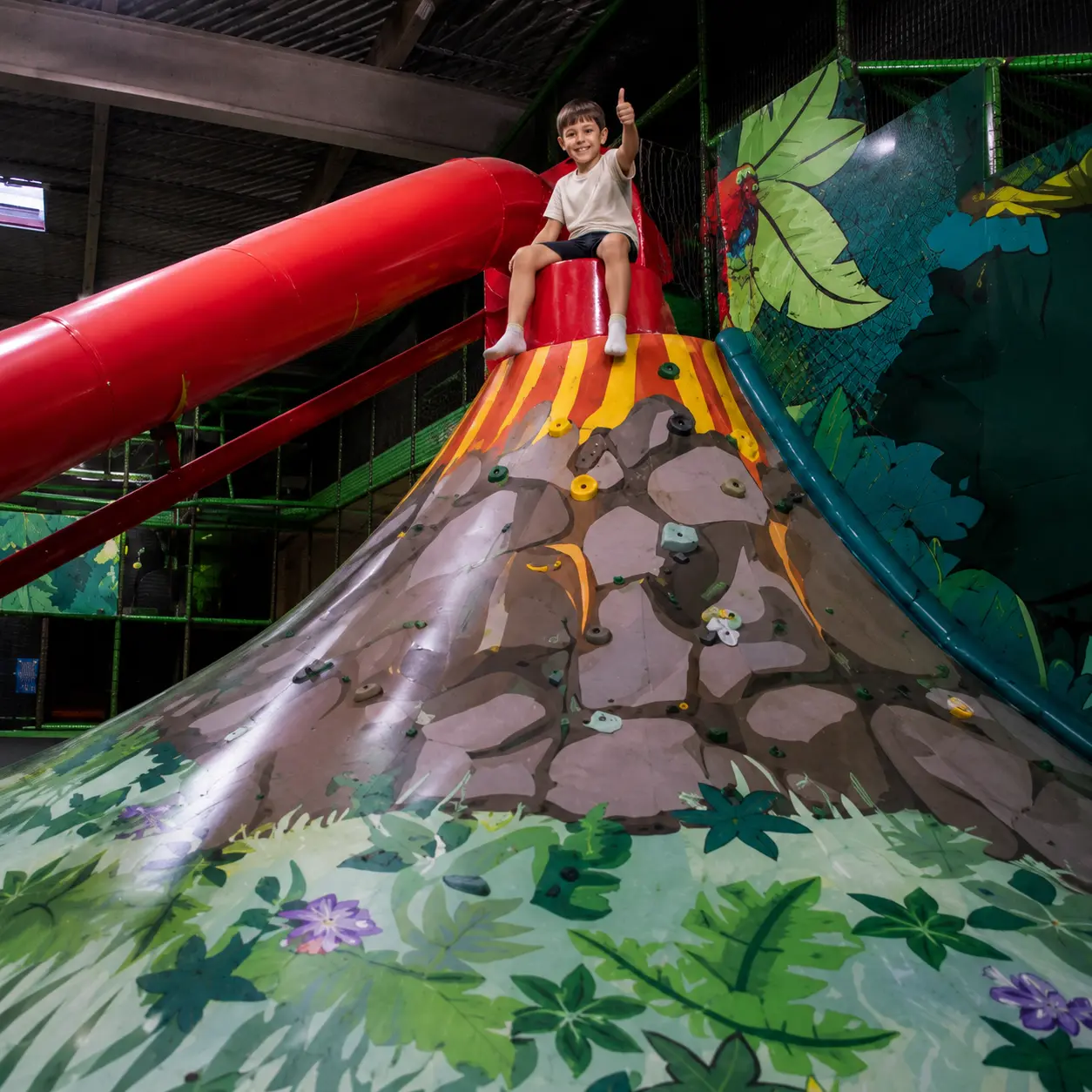 Enfant volcan parc de jeux interieur pouce en l'air