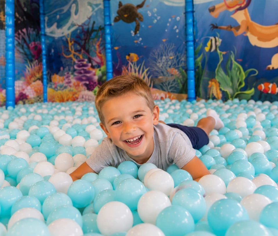 enfant souriant dans piscine à balle youkids