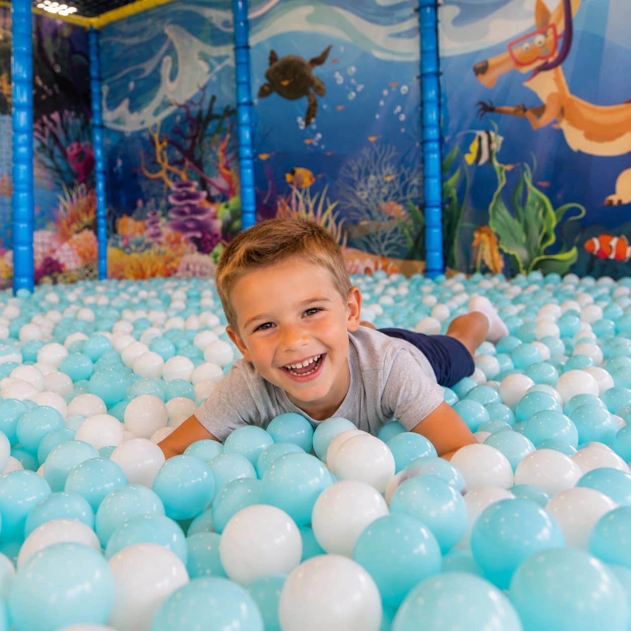 enfant souriant dans piscine à balle youkids